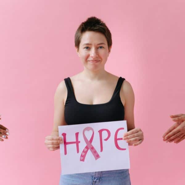 breast cancer fighting women carry a cardboard with "hope" writing